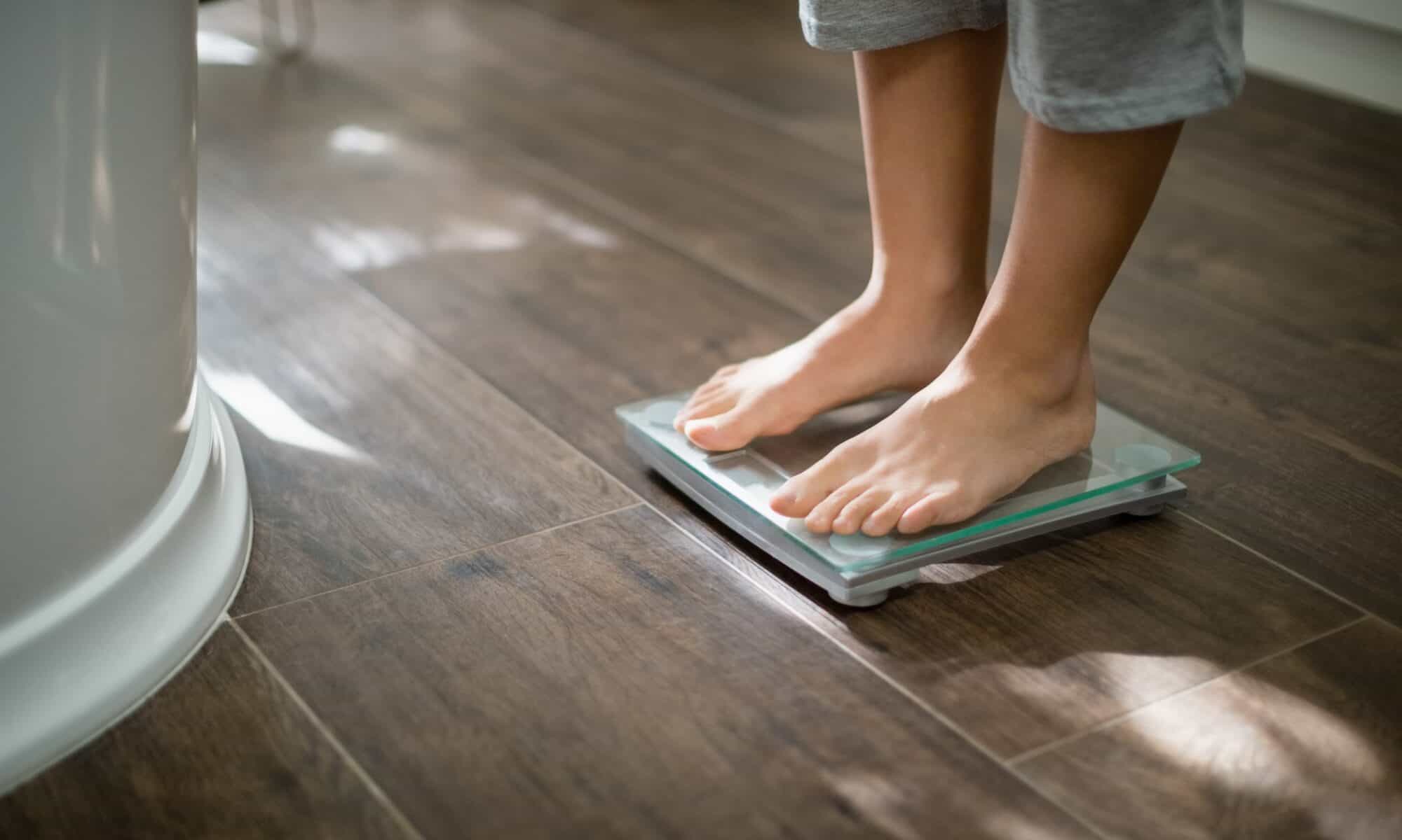 feet standing on weight scale in bathroom